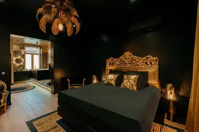 a bedroom with a bed and a black wall at Designer Hôtel in Heusy