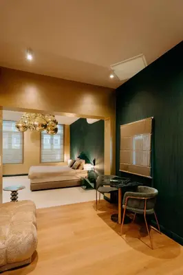 a living room with a bed and a table at Designer Hôtel in Heusy