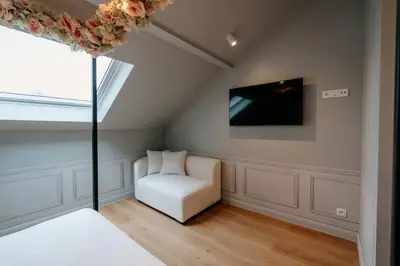 a room with a white chair and a television at Designer Hôtel in Heusy