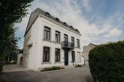 a white building with a balcony on top of it at Designer Hôtel in Heusy