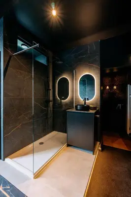 a bathroom with a shower with a glass wall at Designer Hôtel in Heusy