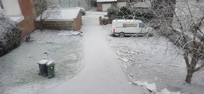 a snow covered driveway with a trash can and a van at CHAMBRE Privée in Seraing