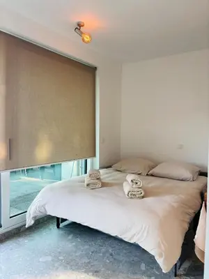 a bedroom with a large bed with towels on it at GG'S studio in Hasselt