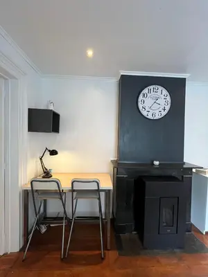a desk with two chairs and a clock on a wall at home sweet home in Liège