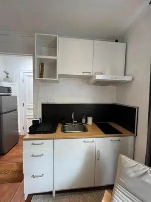 a kitchen with white cabinets and a sink at home sweet home in Liège