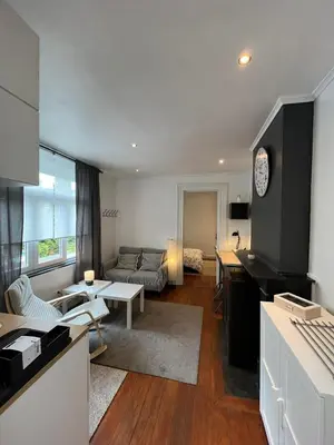 a kitchen and living room with a couch and a table at home sweet home in Liège