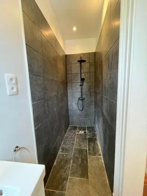 a bathroom with a shower with gray tiles at home sweet home in Liège