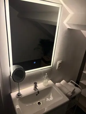 a bathroom sink with a large mirror above it at La suite 7 Sauna et jacuzi in Seraing