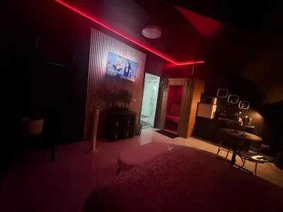 a dark room with a bed and a red light at La suite 7 Sauna et jacuzi in Seraing