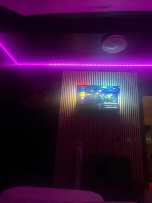 a room with a tv and a purple light at La suite 7 Sauna et jacuzi in Seraing