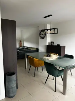 a dining room with a glass table and chairs at Duplex appartement met 3 slaapkamers in Genk