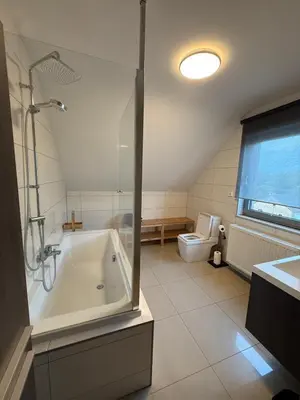 a bathroom with a shower and a tub and a toilet at Duplex appartement met 3 slaapkamers in Genk