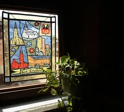 a plant sitting on a window sill next to a stained glass window at Luxe loft in vierkantshoeve in Sint-Truiden