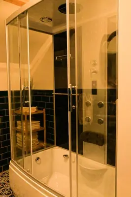 a shower with a glass door in a bathroom at Luxe loft in vierkantshoeve in Sint-Truiden