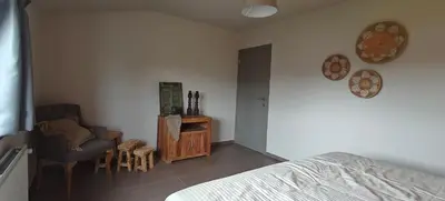 a bedroom with a bed and a chair and a table at Het Mezennest in Zonhoven