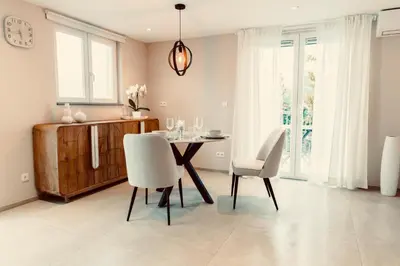 a dining room with a table and white chairs at La Suite Kalys in Thimister