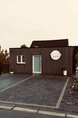 a building with a blue door and a parking lot at La Suite Kalys in Thimister