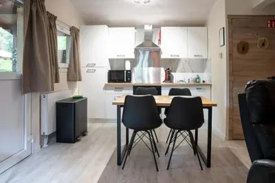 a kitchen with a table and chairs in a room at Chalet Bos en Pootjes in Lanaken