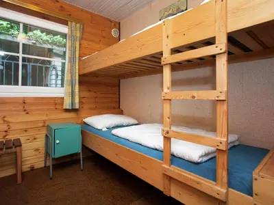 a bedroom with bunk beds in a log cabin at Forest Chalet in Lanklaar in Lanklaar