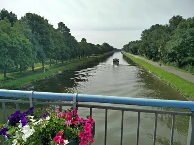 a boat on a river with flowers on a bridge at Forest Chalet in Lanklaar in Lanklaar
