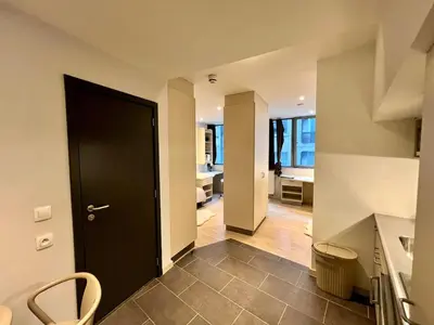 a hallway with a black door and a kitchen at Business trip - Sauna, gym, rooftop in Liège