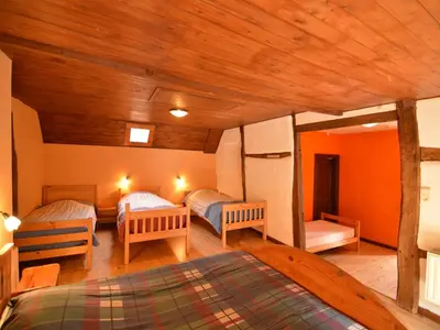a bedroom with two beds in a room with wooden ceilings at Farm Stay with Sauna, Teuven in Teuven