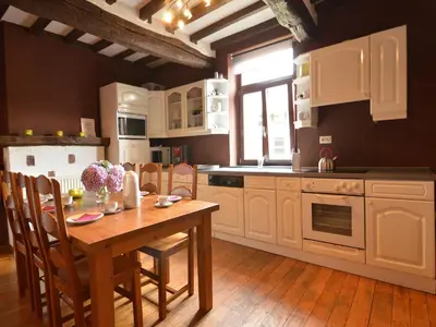 a kitchen with a wooden table and a kitchen with white cabinets at Farm Stay with Sauna, Teuven in Teuven