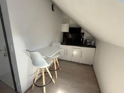 a white table and chairs in a small room at Melo in Plombières