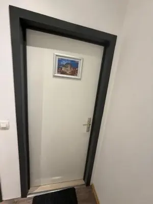 a white wall with a mirror in a room at Melo in Plombières