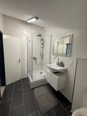 a bathroom with a sink and a shower and a toilet at Melo in Plombières