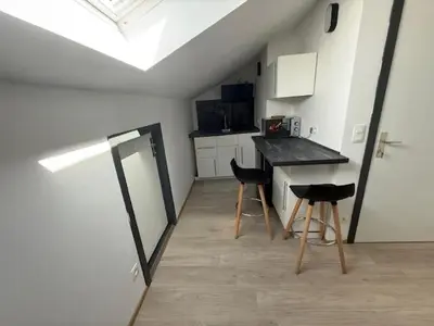 a kitchen with a counter and stools in a room at Melo in Plombières