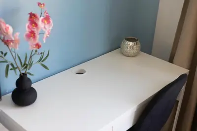 a white table with a vase with flowers on it at Chambres de luxe SDB WC Privés in Liège