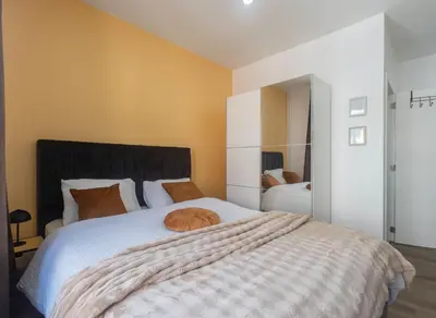 an orange cat sleeping on a bed in a bedroom at Chambres de luxe SDB WC Privés in Liège