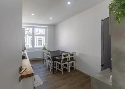 a kitchen and dining room with a table and chairs at Chambres de luxe SDB WC Privés in Liège
