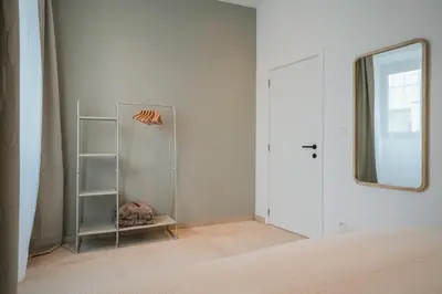 a white room with a mirror and a closet at Superbe appartement 2 chambres en centre-ville in Liège