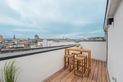 a balcony with two chairs and a table on a roof at Superbe appartement 2 chambres en centre-ville in Liège