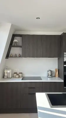 a kitchen with brown cabinets and a white counter top at Superbe appartement 2 chambres en centre-ville in Liège