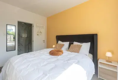 a bedroom with a large white bed with two pillows at Appartement de luxe Dubai , Chambre, salon et SDB Privés, cuisine partagée in Liège