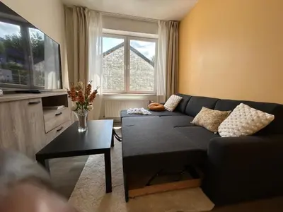 a living room with a couch and a table at Appartement de luxe Dubai , Chambre, salon et SDB Privés, cuisine partagée in Liège