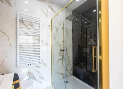 a shower with a glass door in a bathroom at Appartement de luxe Dubai , Chambre, salon et SDB Privés, cuisine partagée in Liège