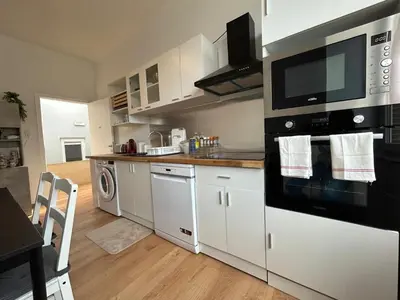 a kitchen with white cabinets and black appliances at Chambre de luxe RIO a Liège Sale de bain privée check in autonome cuisine partagée in Liège