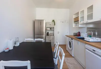 a kitchen with a black table and white appliances at Chambre de luxe Tokyo a Liège Sale de bain privée check in autonome cuisine partagée in Liège
