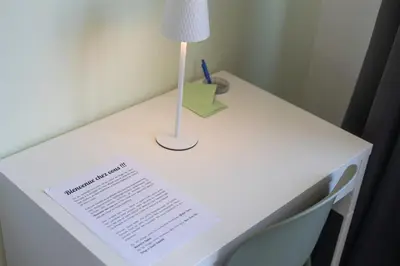 a white desk with a lamp and a paper on it at Chambre de luxe Tokyo a Liège Sale de bain privée check in autonome cuisine partagée in Liège