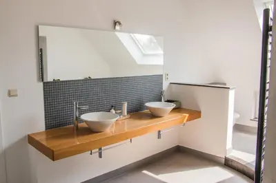 a bathroom with two sinks on a wooden counter at Green& Light House16 in Kettenis