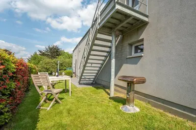a patio with a table and a stool next to a building at L étage in Soumagne