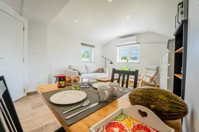 a kitchen and living room with a table and a dining room at L étage in Soumagne