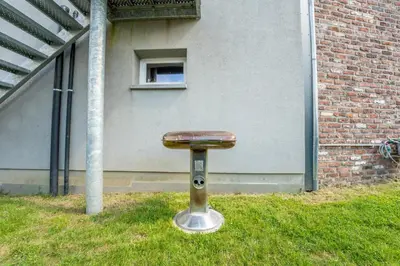 a stool sitting in the grass in front of a building at L étage in Soumagne