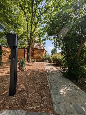 a parking meter in a yard with a house at la pomme de pin Cornesse