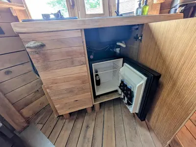 a kitchen with a wooden counter with a small refrigerator at la pomme de pin Cornesse