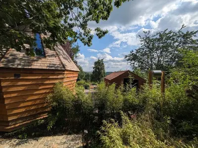 a wooden house with a garden in the foreground at la pomme de pin Cornesse